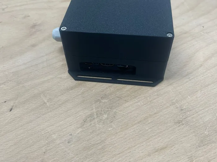 Schwarzes, kantiges Gehäuse für Elektronik auf einer Holzplatte
