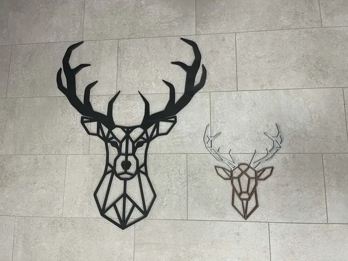 Zwei Hirschköpfe aus schwarzen und braunen Linien als flache Wanddekoration