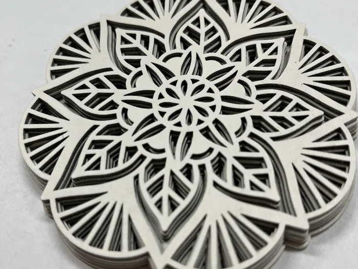 Mandala aus mehreren übereinanderliegenden, fein ausgeschnittenen Holzlagen