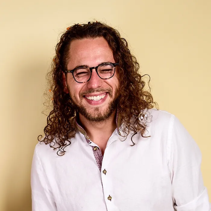 Nikola Djordjevic, lachend, mit Brille und langen Locken