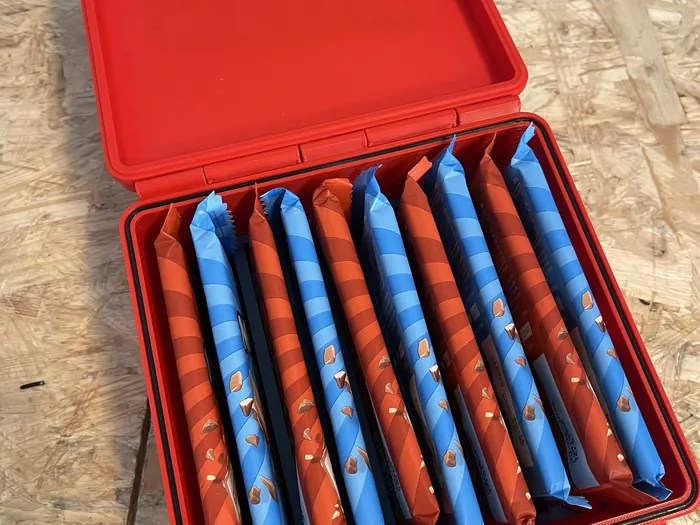 Geöffnete rote Box, in der zehn Riegel nebeneinander stehen