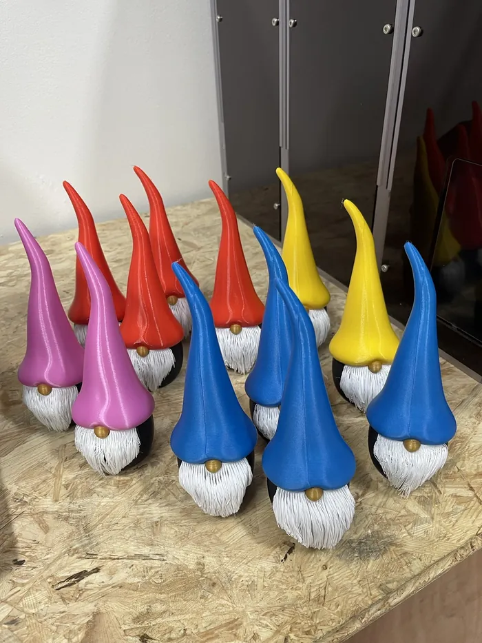 Eine Gruppe Zwerge mit langen, spitzen Mützen in Rot, Blau, Gelb und Pink